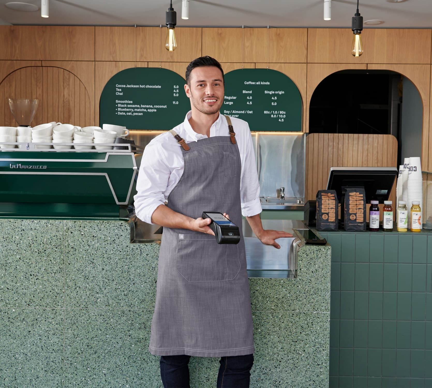 Zeller – Cafe owner holding black Zeller Terminal